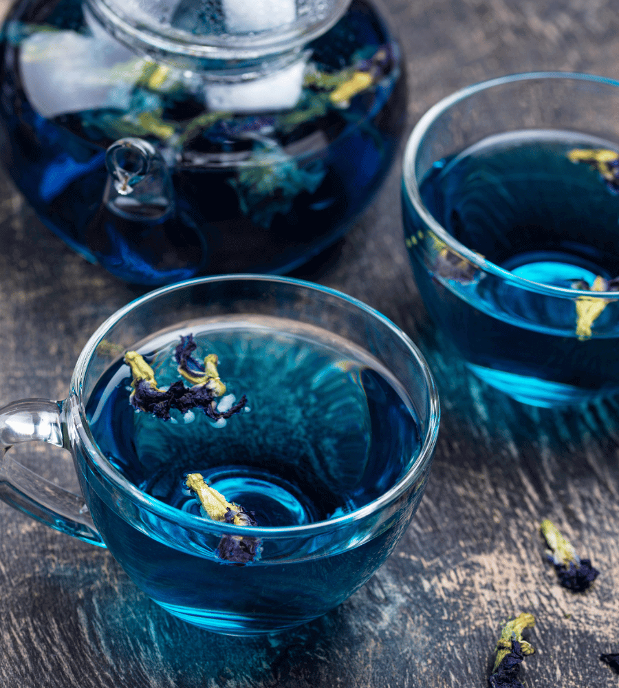 Tassen mit und eine Teekanne mit blauem Lotus Tee